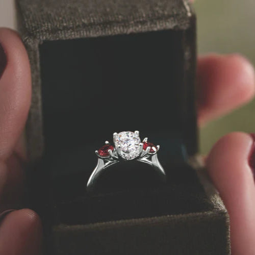 A diamond and ruby ring held in an open ring box