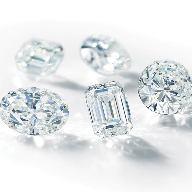 Loose diamonds in several shapes on a white surface