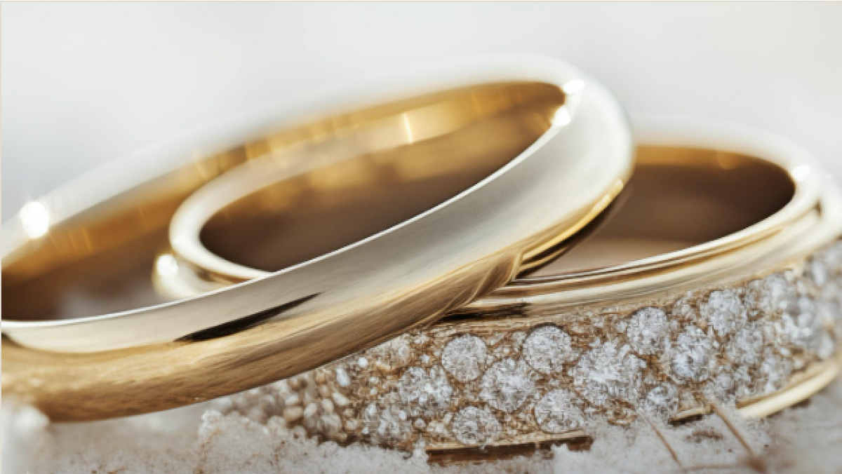 A diamond wedding band and a gold band resting together