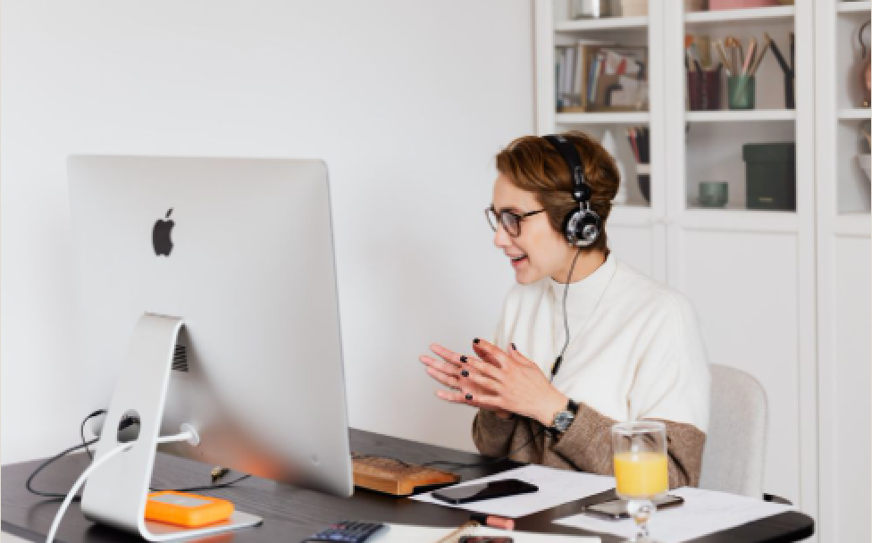 A client smiling during a video consultation at her computer