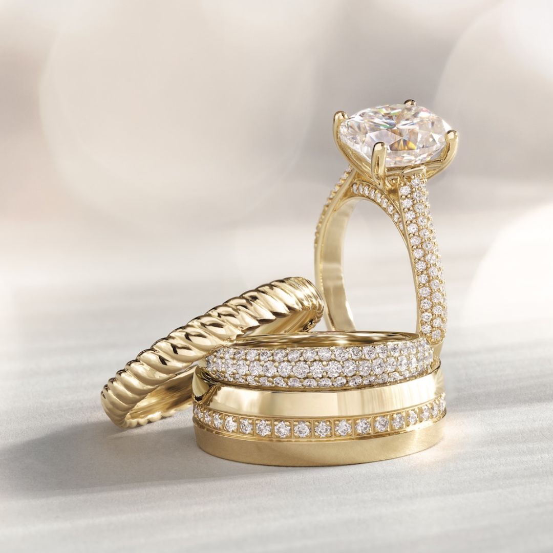 Yellow gold wedding bands stacked beside a diamond engagement ring